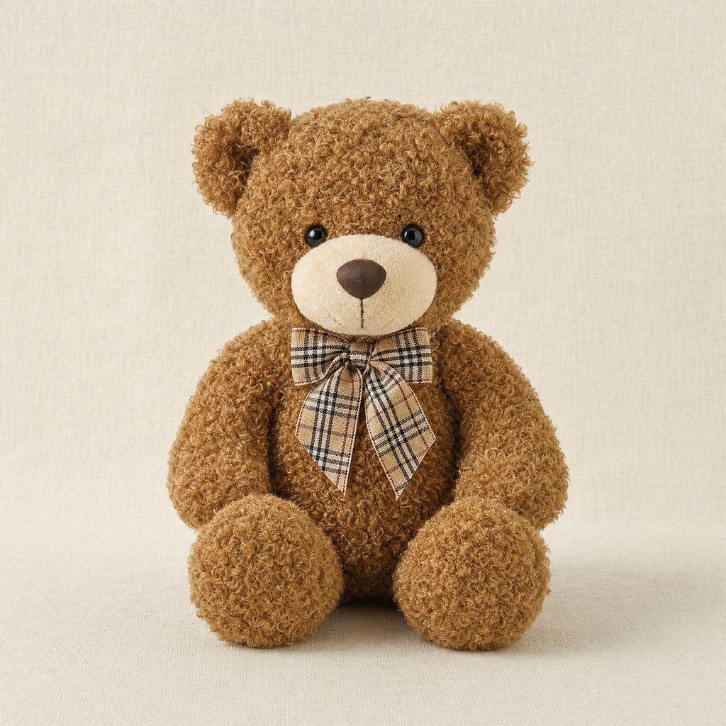 Ours en peluche marron avec nœud papillon à carreaux, vue de face sur fond crème