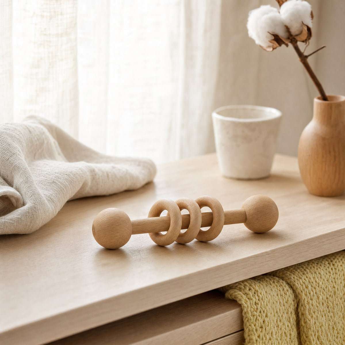 Hochet en bois à anneaux posé dans une chambre de bébé