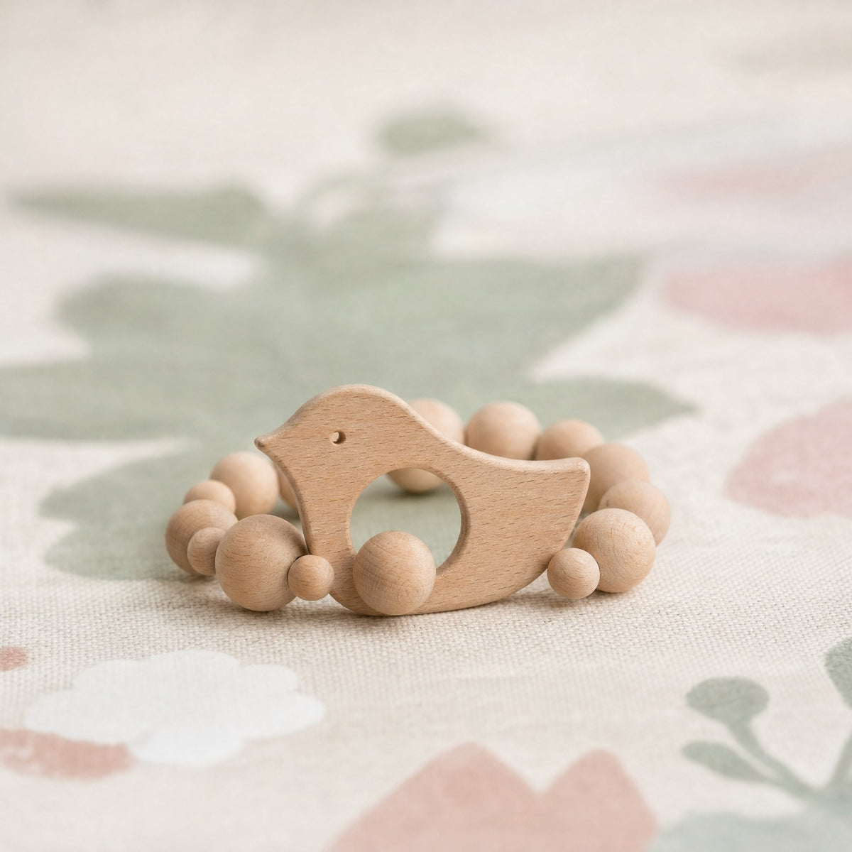 Anneau de dentition en bois posé sur un tapis de jeu bébé