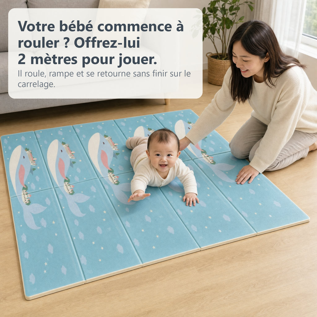 Bébé qui rampe sur le tapis de jeu baleine et football dans un salon, sa mère agenouillée à côté