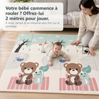 Bébé qui rampe sur le tapis de jeu pique-nique et petit train dans un salon, sa mère agenouillée à côté