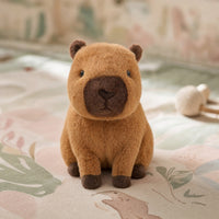 Peluche capybara posée sur un tapis de jeu bébé