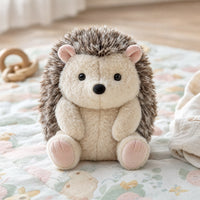 Peluche hérisson posée sur un tapis de jeu bébé