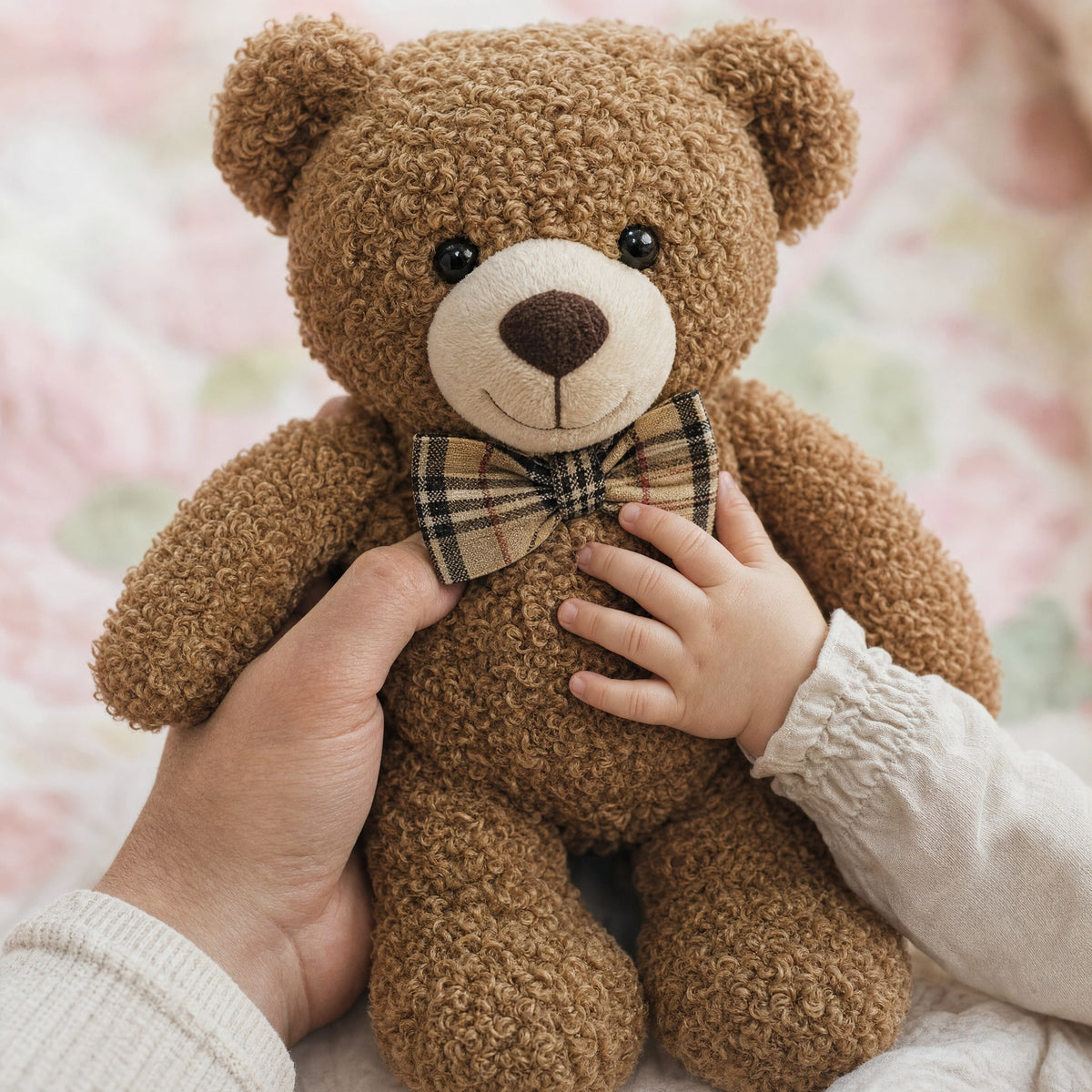 Main d'un parent et d'un bébé tenant l'ours en peluche