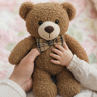 Main d'un parent et d'un bébé tenant l'ours en peluche