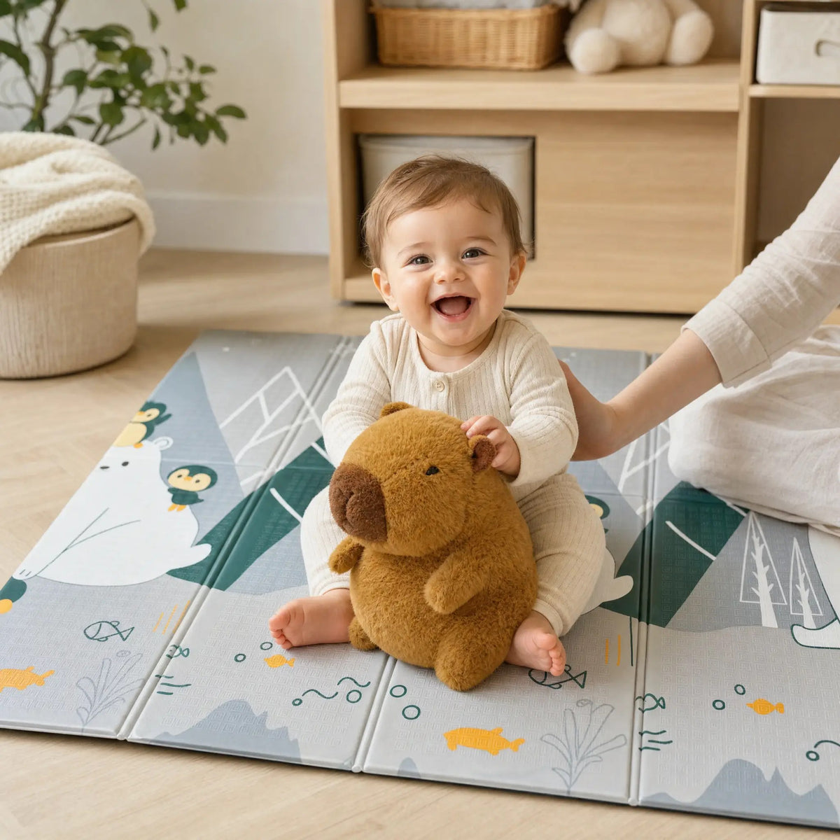 Bébé souriant avec sa peluche capybara sur le tapis de jeu pliable ECLOA Ours polaires