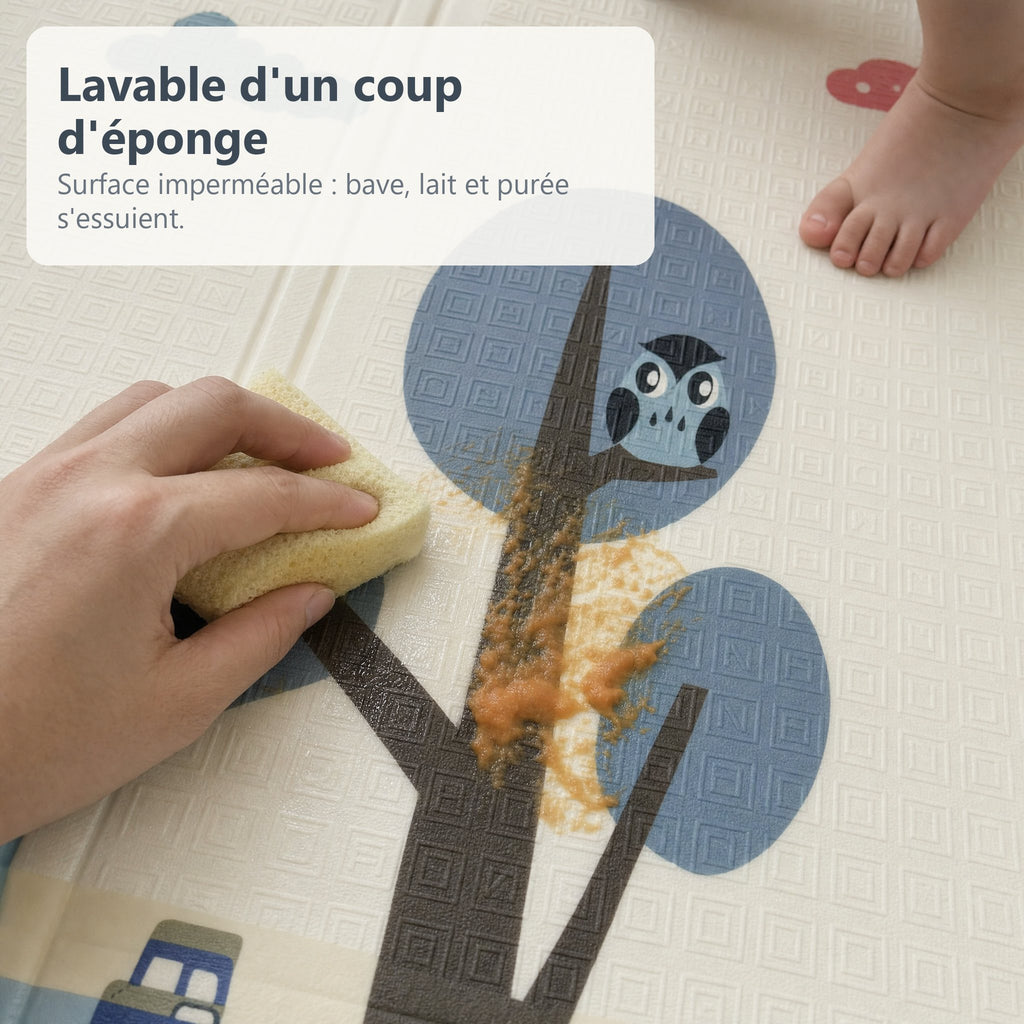 Une main essuie de la purée d'un coup d'éponge sur le tapis de jeu imperméable biche et Good morning