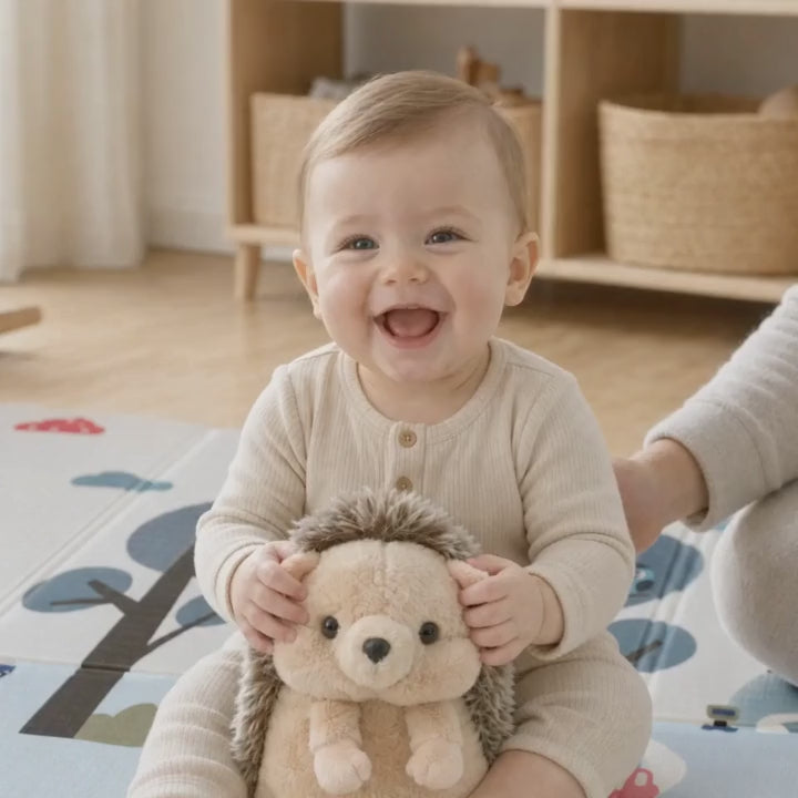 Bébé qui lève puis serre la peluche hérisson sur un tapis de jeu ECLOA